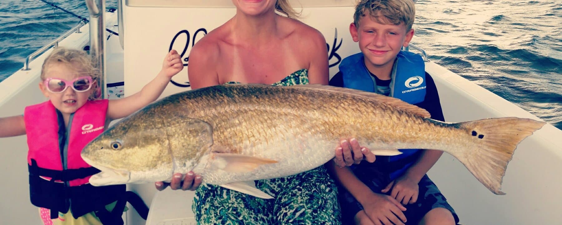Big bull redfish held up on a boat in the bay